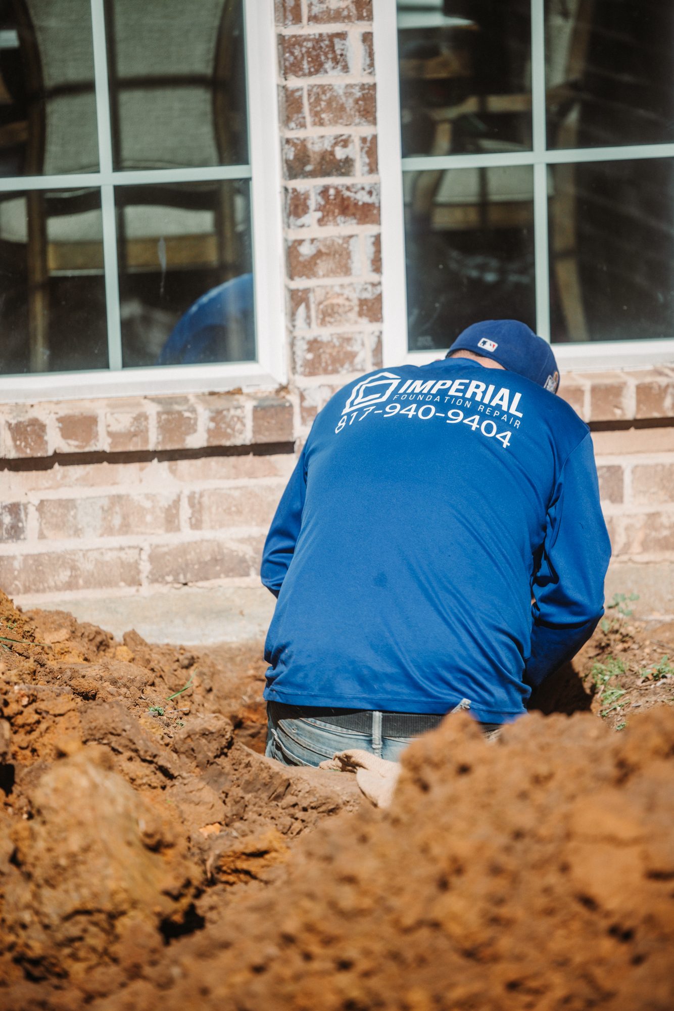 Crew in trench branded, Imperial Foundation Repair job site in North Texas